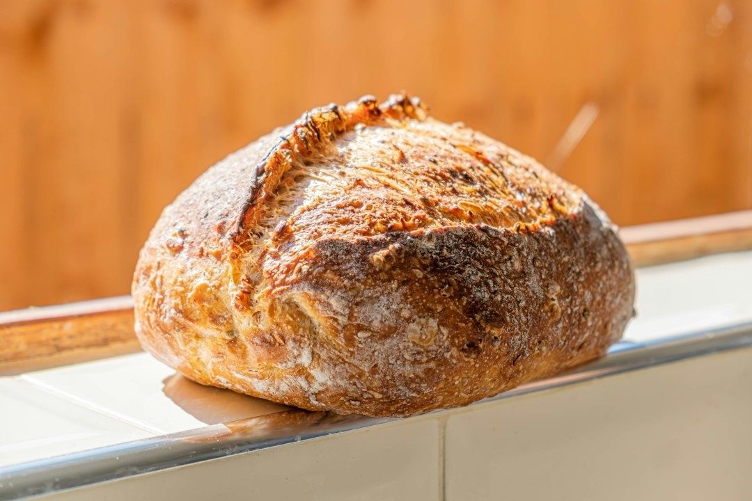 Rundgräddat surdegsbröd med mörk, sprucken och mjölig skorpa